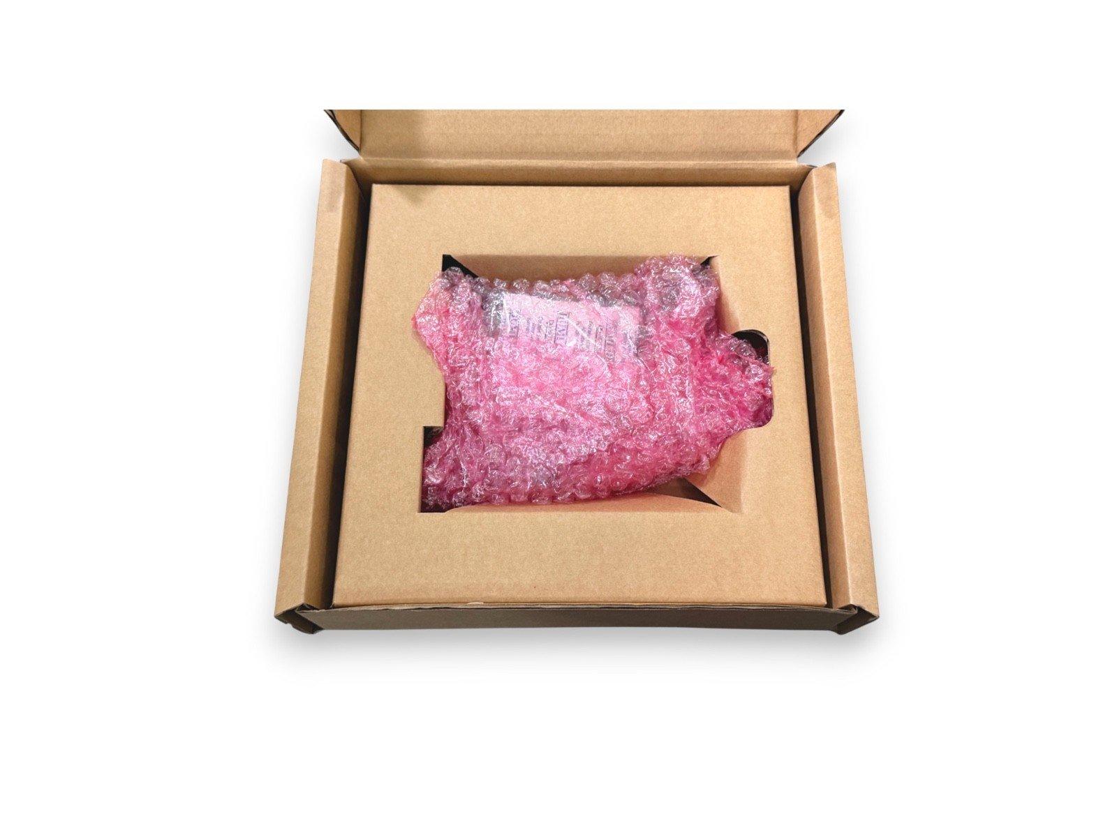 Fire alarm equipment packed in pink bubble wrap inside a cardboard box for safe shipping