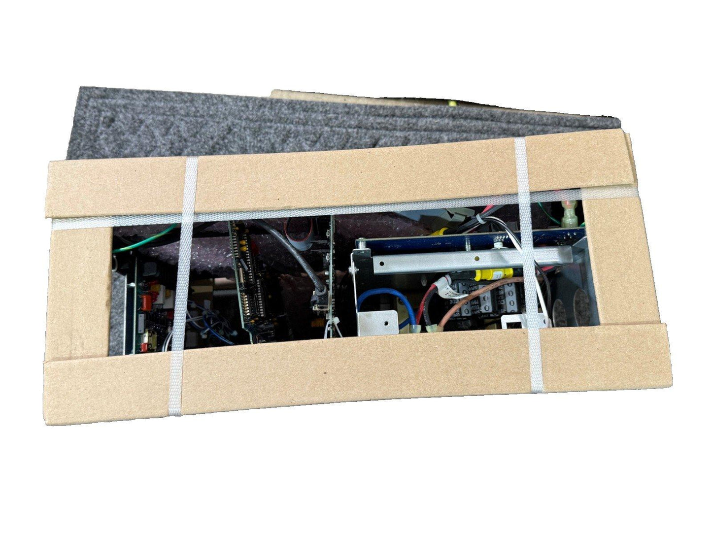 Fire alarm control panel with wiring, secured in cardboard packaging for shipping
