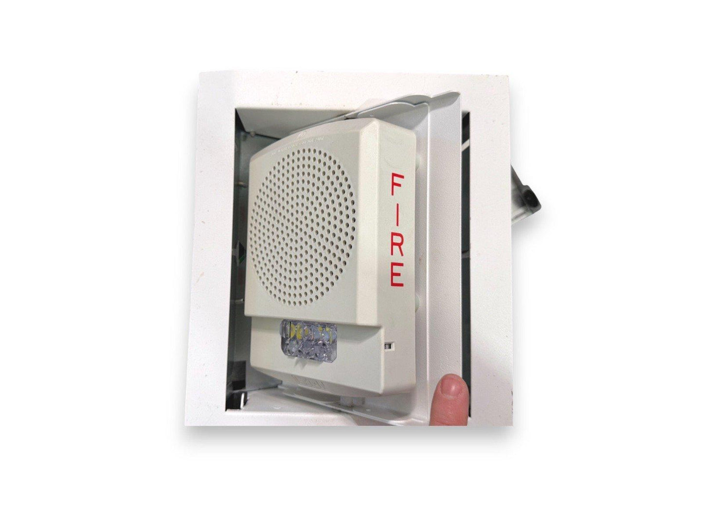 White fire alarm horn strobe with red FIRE label, mounted in ceiling, showing LED light and speaker grille.