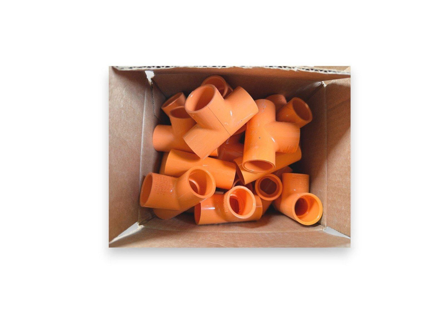 Orange PVC pipe fittings in a cardboard box for fire alarm system installation
