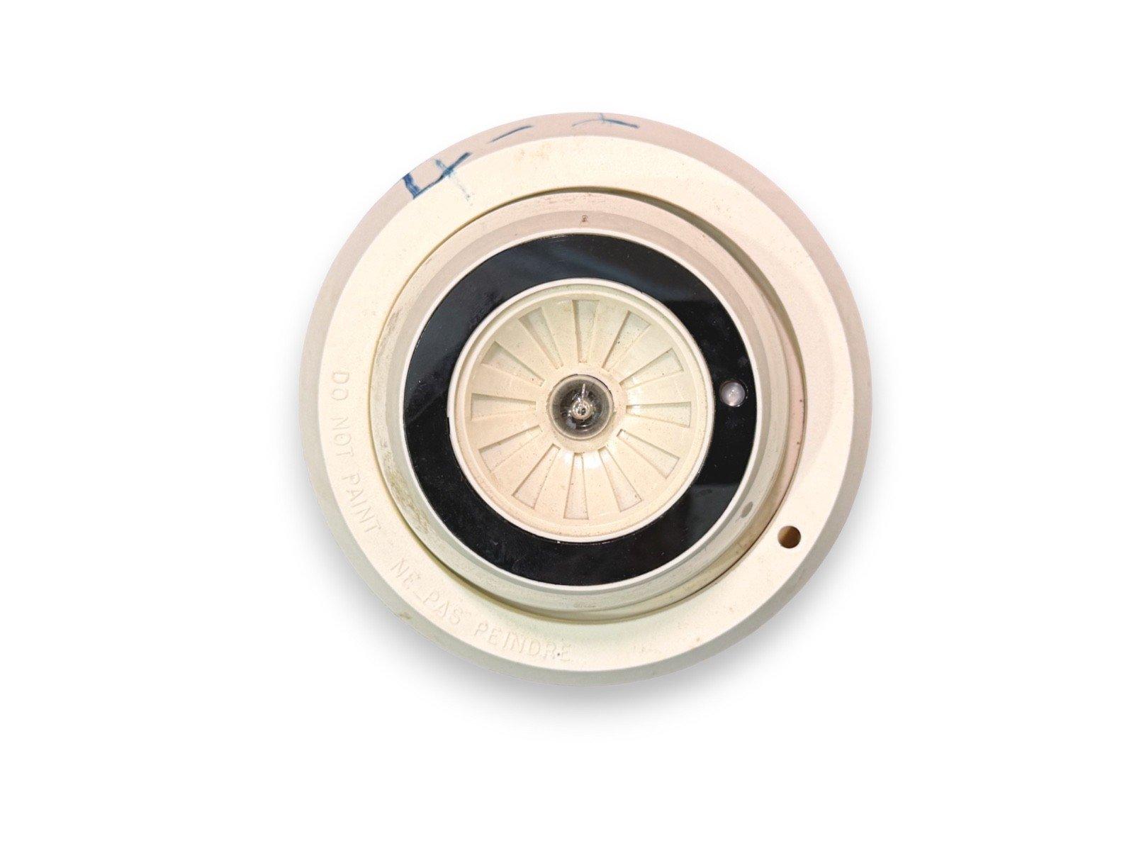 Used fire alarm smoke detector with "Do Not Paint" warning, circular beige design, black center