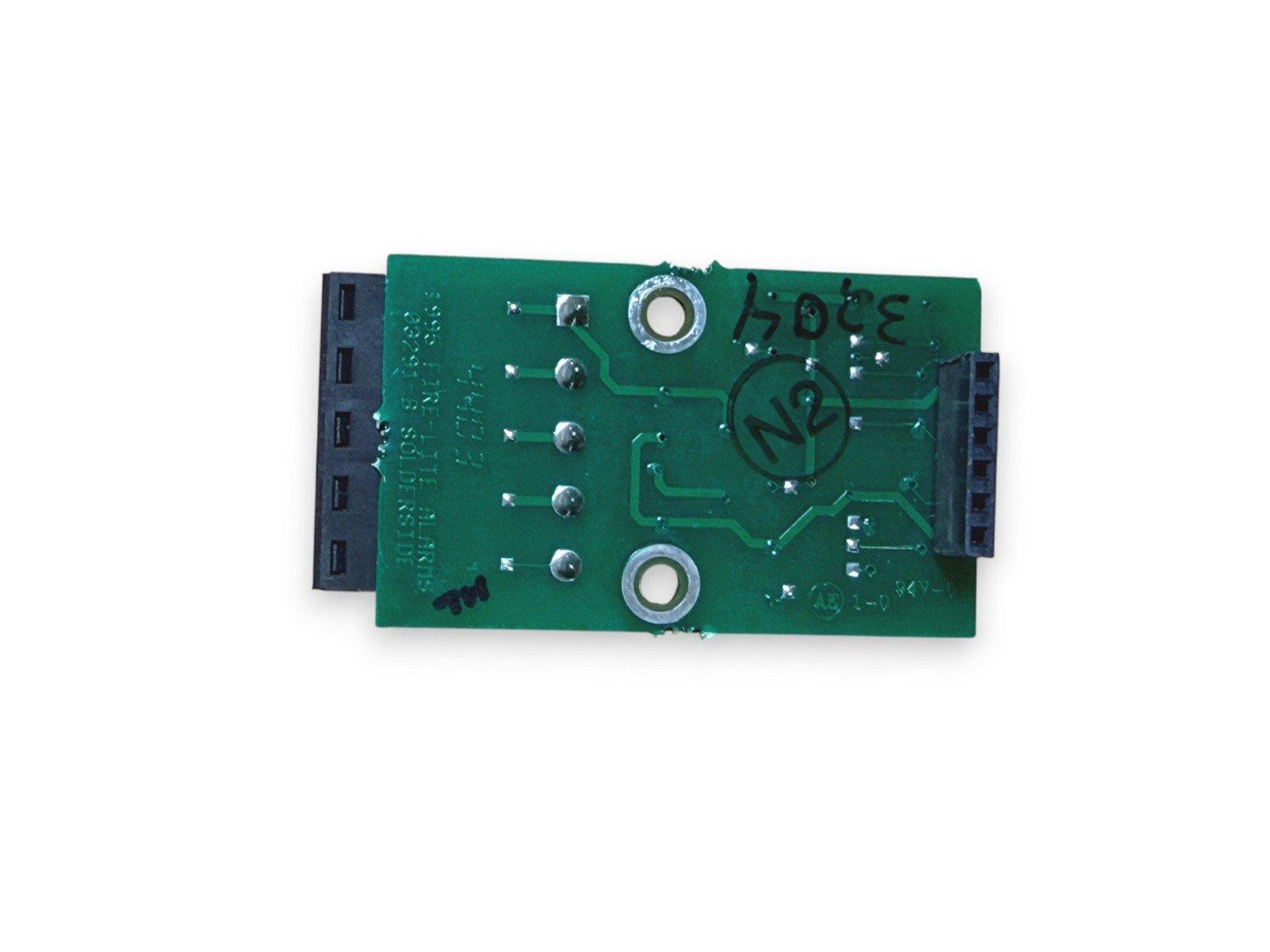 Green fire alarm circuit board with connectors and solder points, used fire alarm equipment
