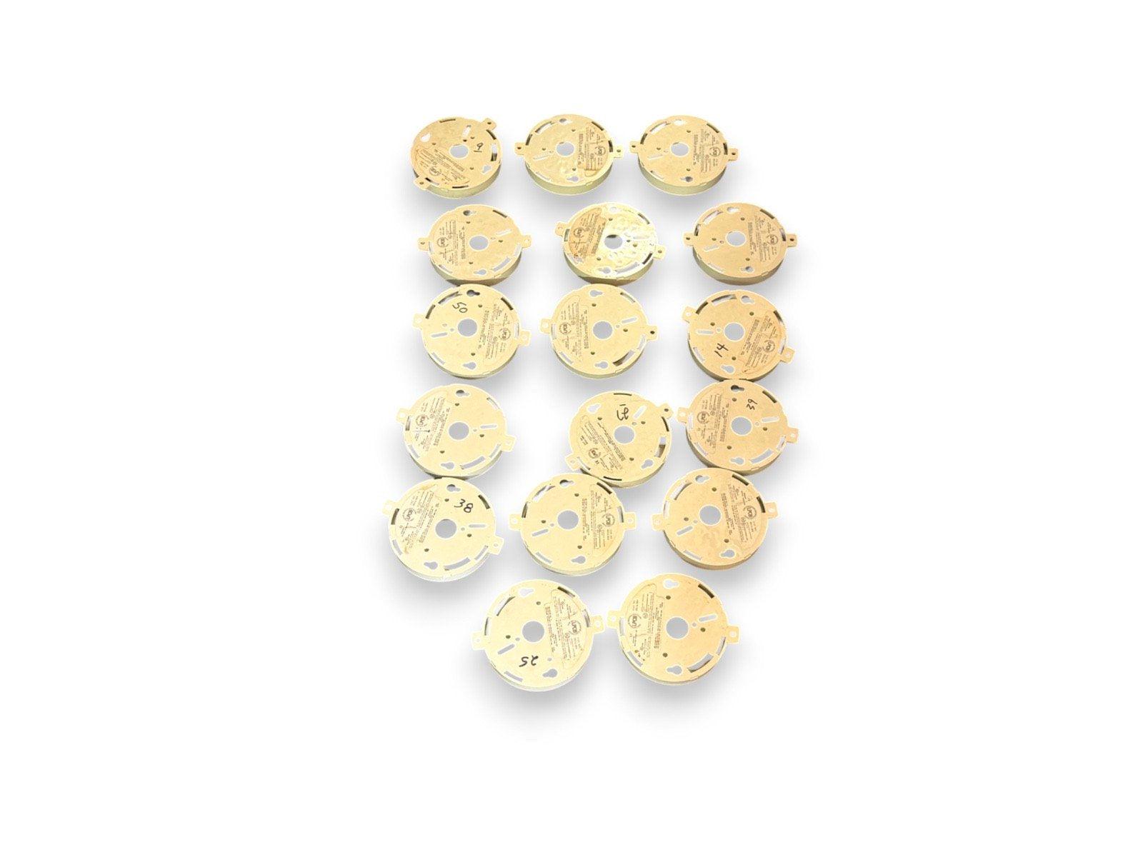 Round fire alarm base plates, used fire alarm equipment, gold-colored mounting bases for smoke detectors