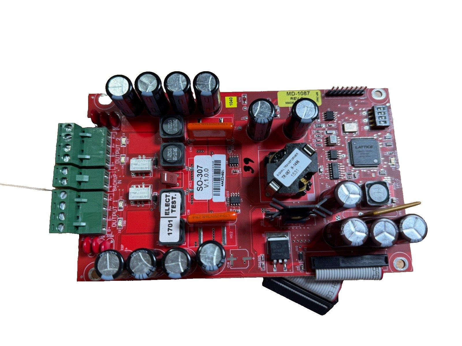 Red fire alarm control panel circuit board with capacitors, connectors, and transformer for fire safety systems